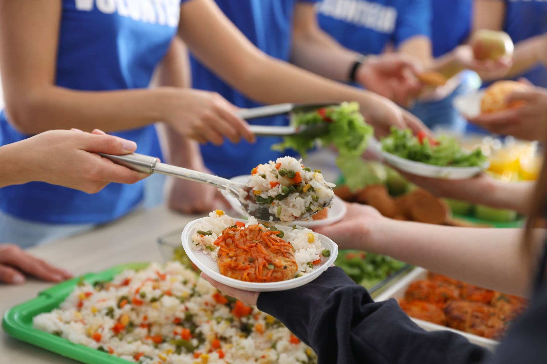 Voluntários distribuindo alimentos